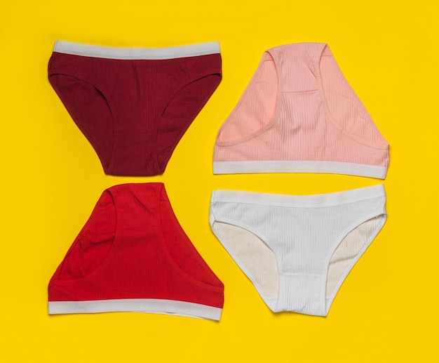 Quatre culottes lumineuses sur fond jaune vif Concept minimal de sous-vêtements féminins