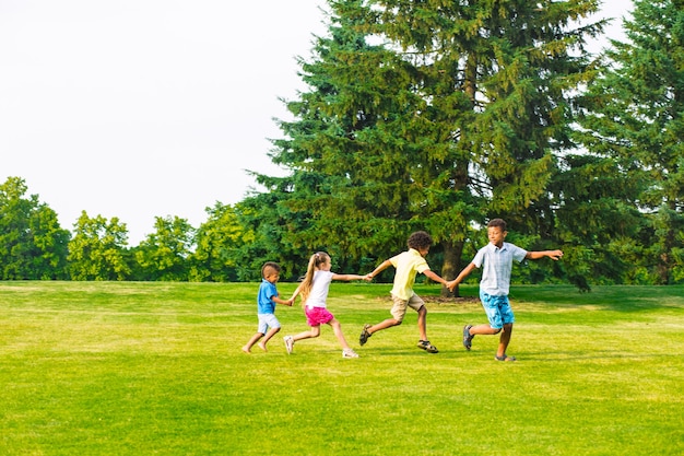 Quatre enfants jouent sur la clairière, ils sautent et rient