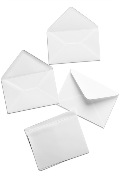 Photo quatre enveloppes blanches sur un fond blanc ordinaire idéal pour les concepts d'affaires et de bureau