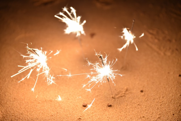 Quatre feux de Bengale sur la plage de sable pour célébrer.