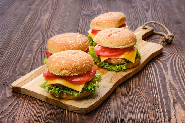 Quatre hamburgers faits maison sur planche de service en bois