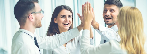 Les quatre hommes d'affaires saluant avec un high five