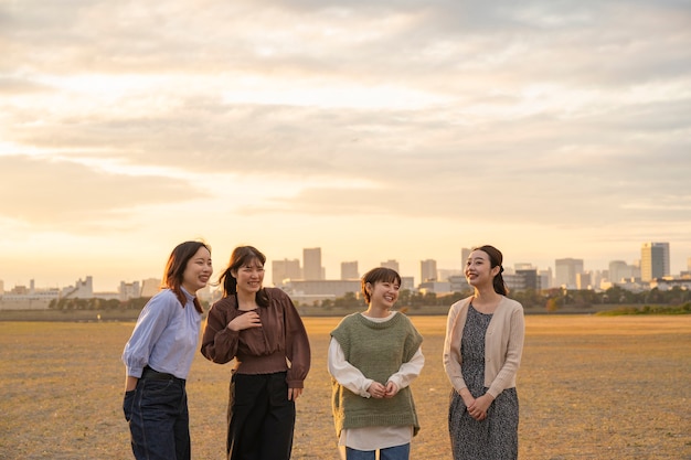 Quatre jeunes femmes asiatiques parlant joyeusement au crépuscule