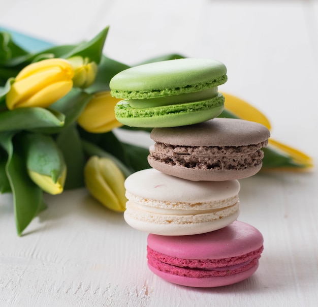 Quatre macarons et tulipes sur la table en bois