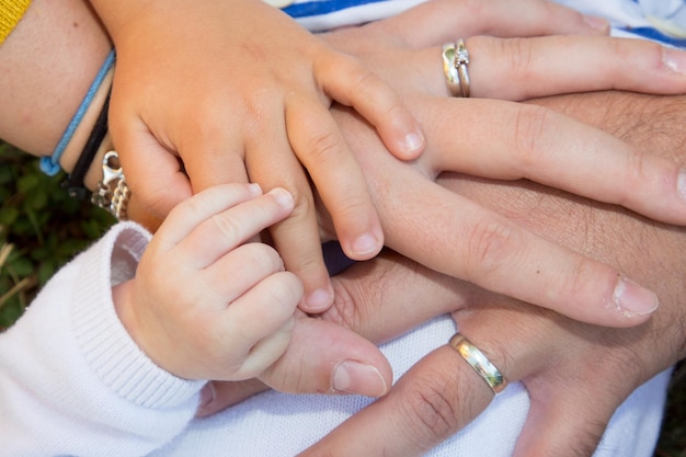 Quatre mains de famille joyeuse bébé fils enfant mère et père