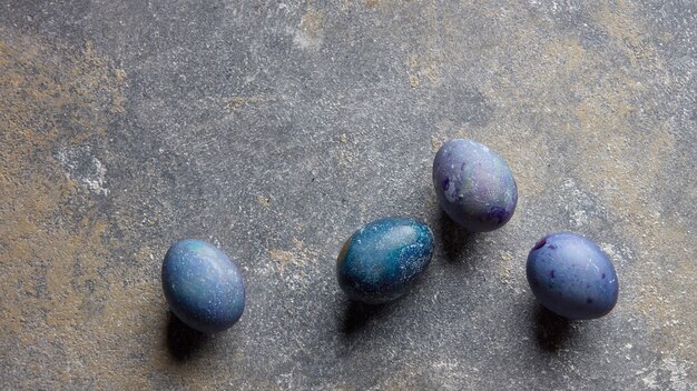 Quatre oeufs colorés sur un fond en pierre