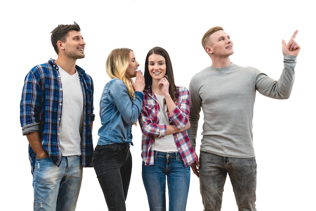 Les quatre personnes heureuses se tiennent debout et font un geste sur le fond blanc