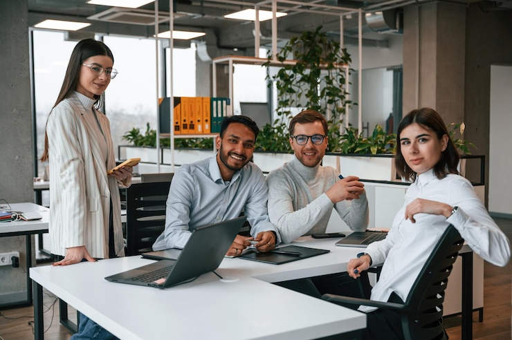 Photo quatre personnes travaillent ensemble dans le bureau.