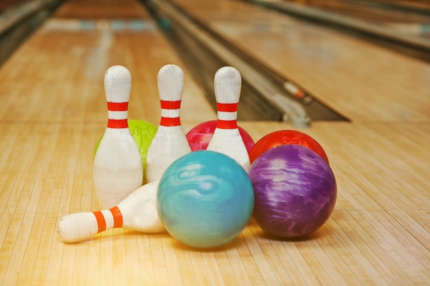 Quatre quilles avec cinq boules de bowling