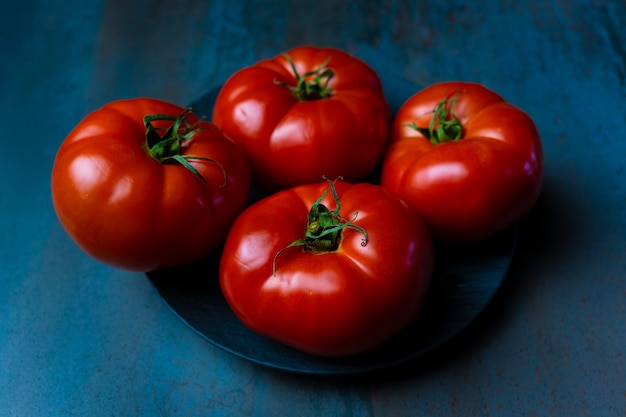 quatre tomates rouges sur fond texturé