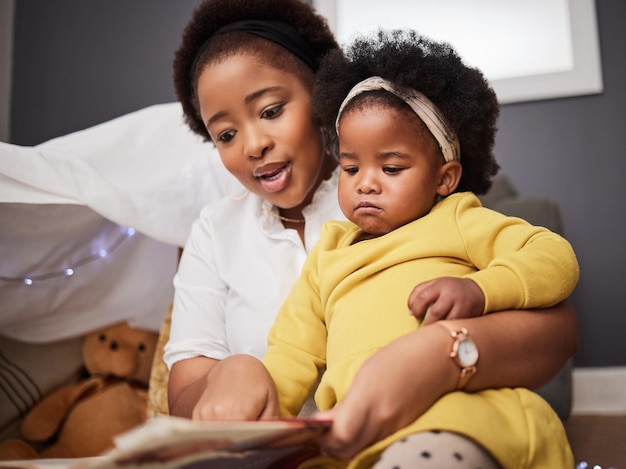 Que lisons-nous aujourd'hui Photo d'une jeune mère et sa fille lisant un livre à la maison