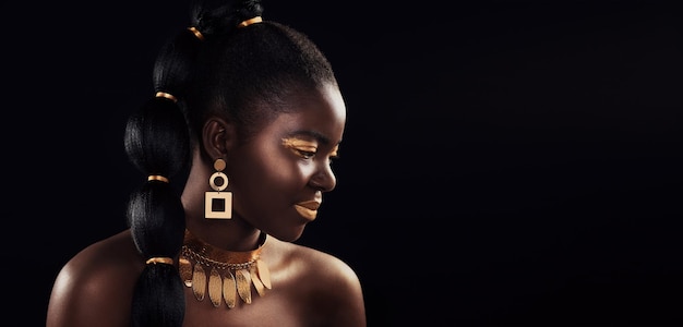 Quelle belle reine de mélanine Prise de vue en studio d'une belle jeune femme portant du maquillage et des bijoux sur fond noir