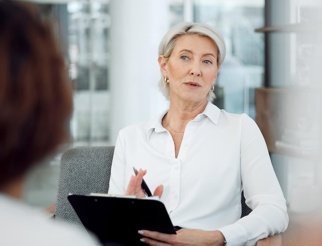 A quelle fréquence ceci se passe-t-il. Photo d'une psychologue mature assise avec sa patiente et utilisant un presse-papiers pendant la consultation.