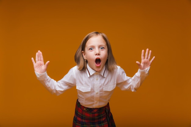 Quelle surprise Écolière enfant surprise sur fond jaune Éducation scolaire Retour à l'école