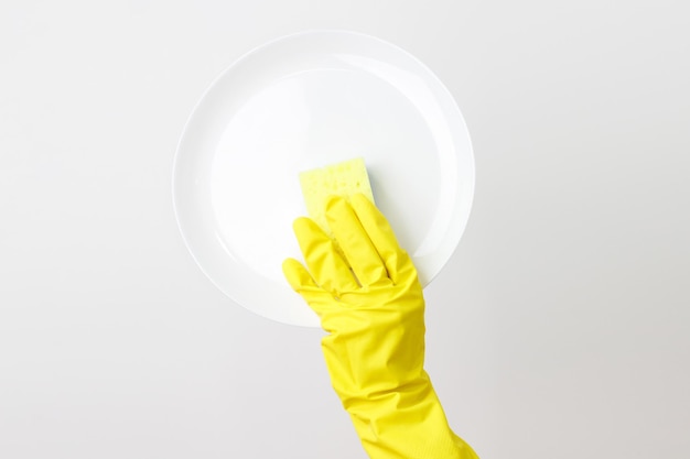 Photo quelqu'un en gants lave une assiette sur un fond blanc