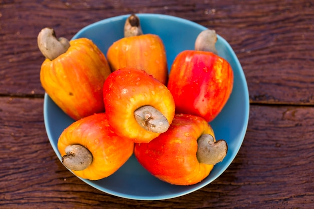 Quelques fruits de cajou sur une surface en bois.