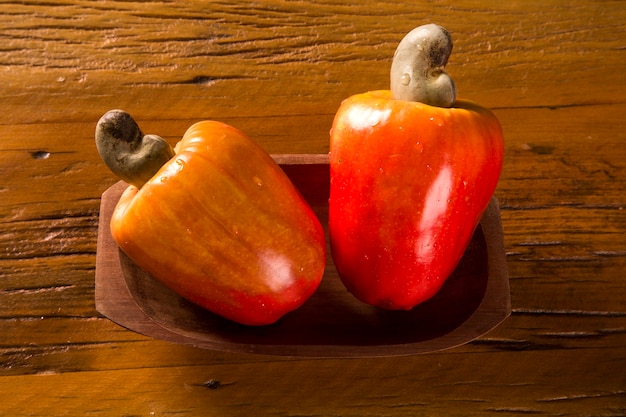 Quelques fruits de cajou sur une surface en bois.