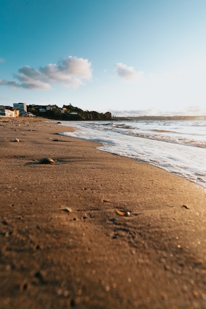 Quelques marées avec des bulles sur la plage de la ville pendant un soleil super coloré