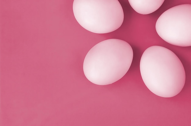 Quelques œufs de Pâques blancs sur un fond lumineux Image tonique en Viva Magenta couleur de l'année