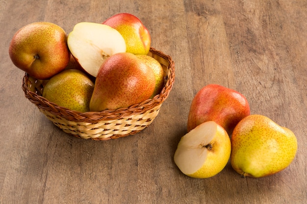 Quelques poires dans un panier sur une surface en bois. Fruits frais