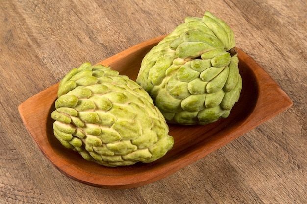 Quelques pommes de sucre sur une table en bois. Fruit d'Atemóia