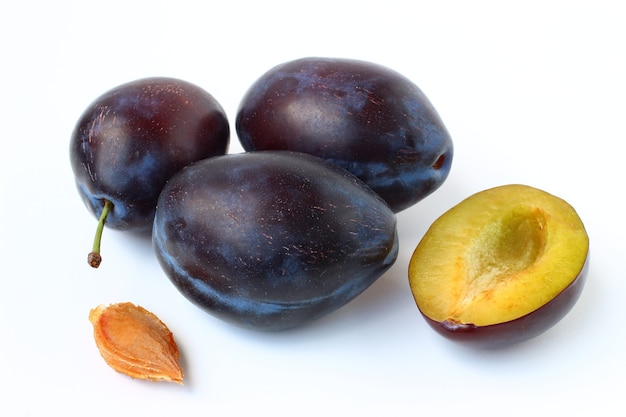 Quelques prunes et chevilles sur fond blanc