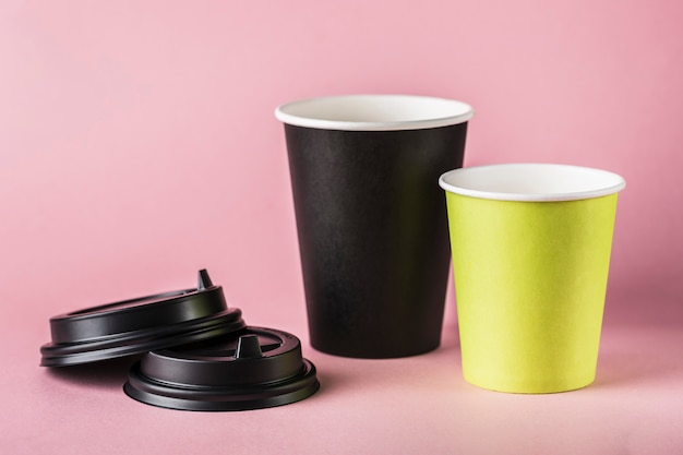 Photo quelques tasses à café réutilisables en papier vert et noir avec couvercle.