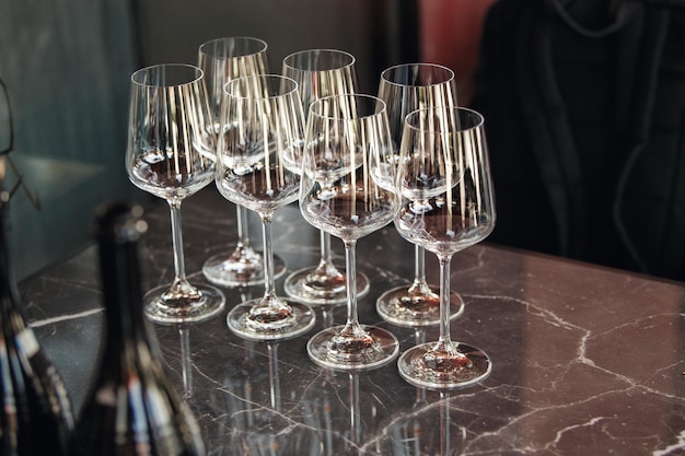 Quelques verres à vin vides sur la table près des bouteilles de vin mousseux Concept de dégustation de vin Restaurant servant