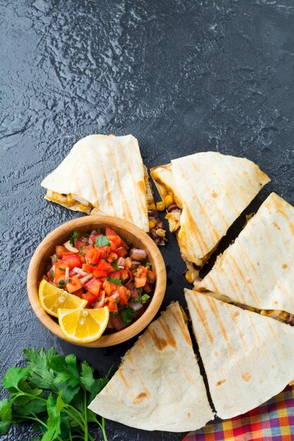 Quesadilla mexicaine avec poulet, maïs, haricots rouges, fromage et poivrons et salsa. Mise au point sélective Vue de dessus.