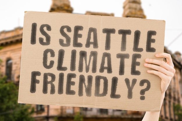 La question Est-ce que Seattle est respectueux du climat est sur une bannière entre les mains des hommes avec un arrière-plan flou Activiste de l'équipe de soutien Coucher de soleil urbain Carbone Écologie Énergie Nouveau Propre Réchauffement Déchets