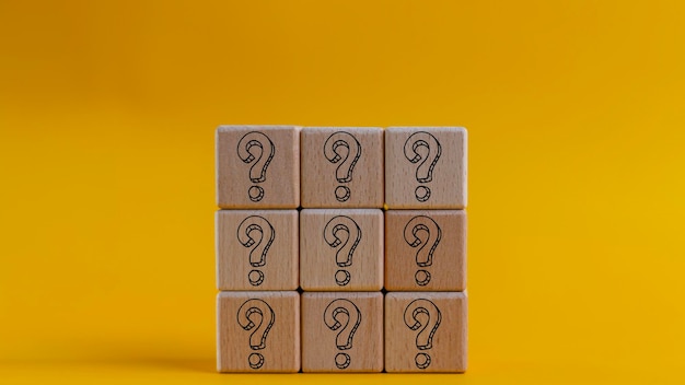 Questions Marquez les mots avec un bloc de cube de bois sur un fond jaune FAQ fréquence des questions posées Réponse Q et A Information Communication et brainstorming Concepts