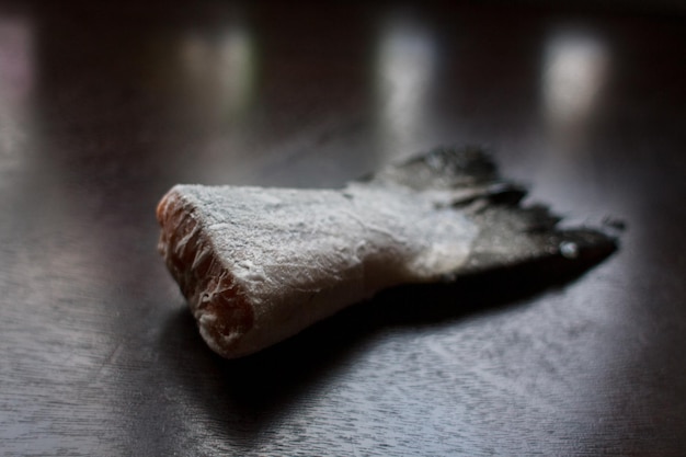 Queue de saumon congelée sur une table de cuisine sombre