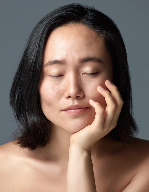 Ce qui est doux et lumineux Ma peau. Prise de vue en studio d'une belle jeune femme posant sur un fond gris.