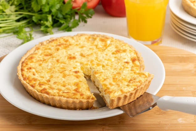 Quiche au fromage une tarte sur une planche de bois une tranche de tarte étant retirée