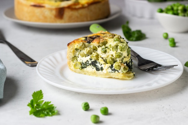 Quiche aux épinards et aux pois verts, tarte ou tarte avec les ingrédients nécessaires pour la cuisson.