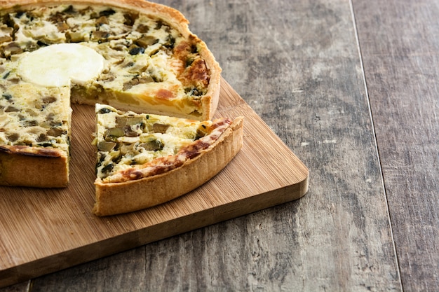 Quiche française avec des légumes sur une table en bois rustique. Espace de copie