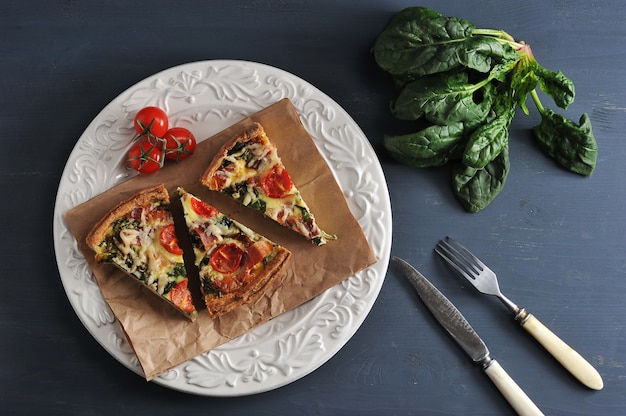 Quiche française avec œufs, épinards, tomates et bacon avec la recette d'un plat délicieux