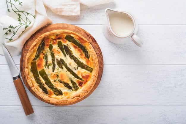 Quiche Tarte aux asperges maison ou quiche au fromage et aux épinards sur fond de table en bois blanc Quiche française traditionnelle Vue de dessus