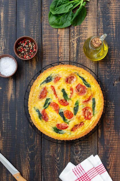 Quiche ou tarte aux tomates, épinards et fromage. Alimentation saine. La nourriture végétarienne. Cuisine française.