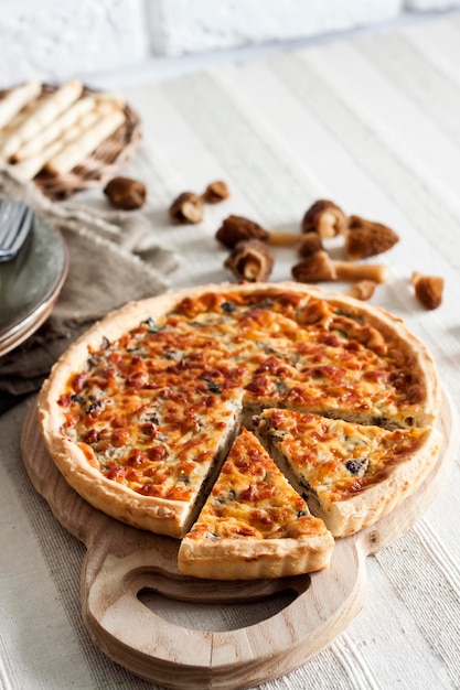 Quiche tarte tarte ouverte aux morilles oignon et fromage sur planche à découper en bois