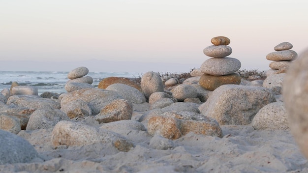 Équilibrage de roche sur la plage de galets des piles pyramidales de pierres de l'eau de mer de la côte de l'océan