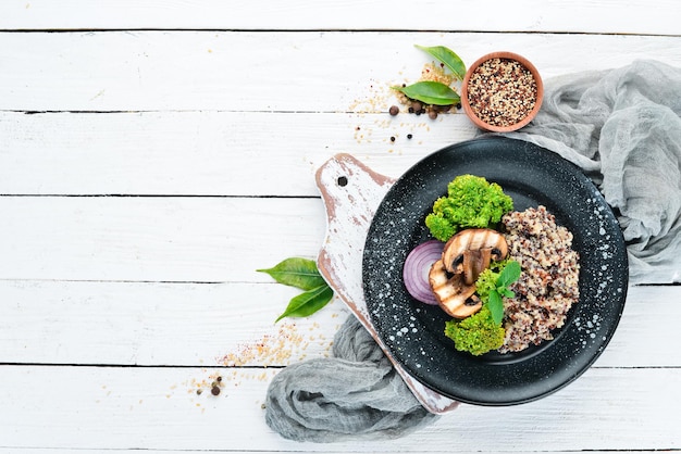 Quinoa aux champignons et légumes sur une assiette. Vue de dessus. Espace libre pour votre texte.