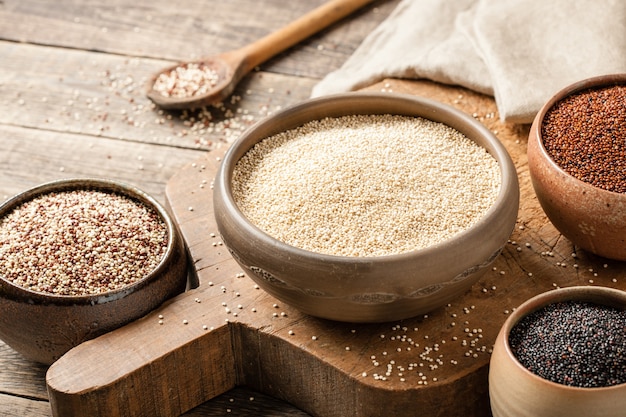 Quinoa blanc, rouge, noir et mixte sur table en bois