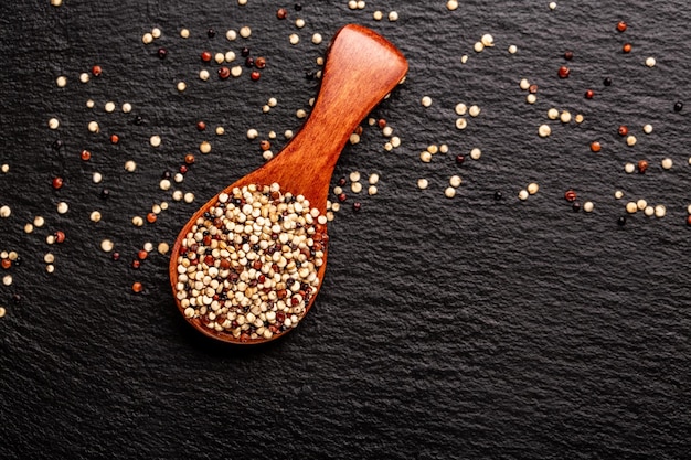 Quinoa cru mélangé dans des bols sur fond de bois Aliments sains et sans gluten Origine Pérou bannière menu recette place pour le texte vue de dessus