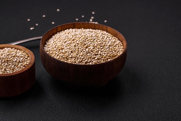 Quinoa cru sain dans un bol sur un fond de béton foncé