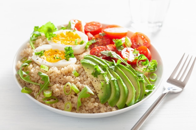 Quinoa avec œuf à la coque, avocat, tomate, roquette. petit-déjeuner sain