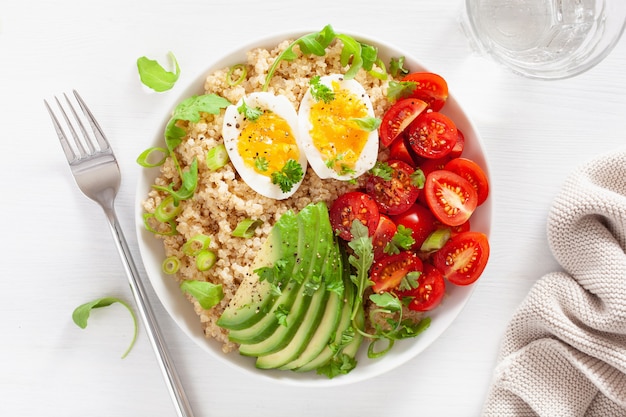 Quinoa avec œuf à la coque, avocat, tomate, roquette. petit-déjeuner sain