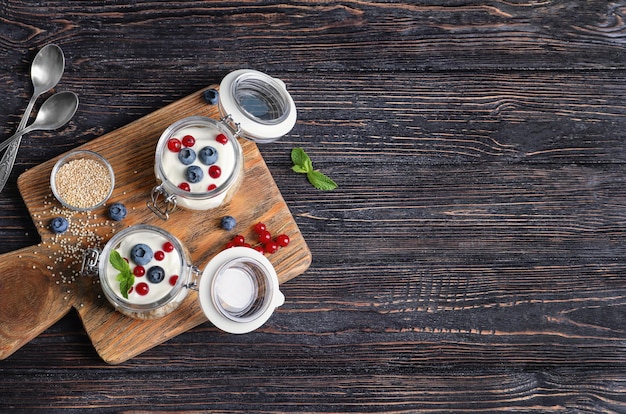 Quinoa savoureux avec des baies dans des bocaux sur une table en bois