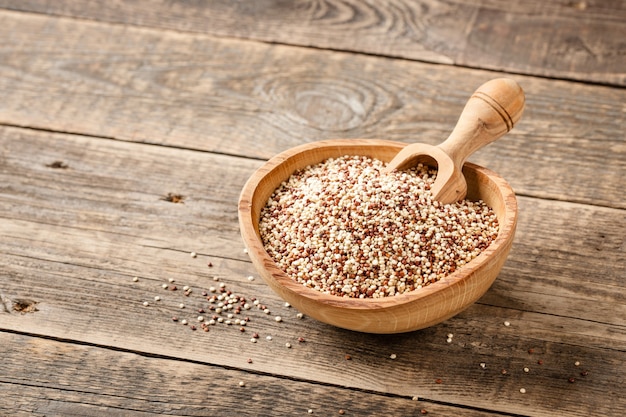 Quinoa sec mélangé dans un bol en bois