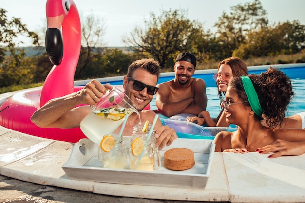 Équipage joyeux profitant de la piscine et buvant des cocktails